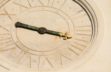 Ancient times and hours. Old clock with lily-shape hand and roman numbers from Trinity of the Mounts Church facade in Rome (16th century)