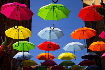 Obraz na płótnie Canvas colored umbrellas hanging against the sky