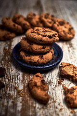 group of tasty cookies next to a bowl on an old wooden board
