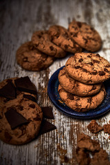 group of tasty cookies next to a bowl on an old wooden board
