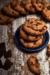 group of tasty cookies next to a bowl on an old wooden board
