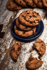 group of tasty cookies next to a bowl on an old wooden board
