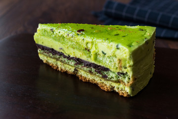 Matcha Green Tea Layer Cake Slice on Dark Wooden Board.