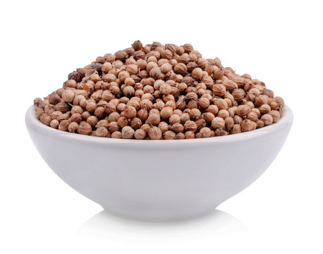 Coriander seeds in a cup of white background