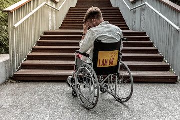 Upset young man sitting in his wheelchair