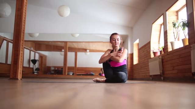 Young attractive yogi woman practicing yoga concept, stretching in Matsyasana exercise, Fish pose, working out, wearing sportswear, full length, white loft studio background. Side view.
