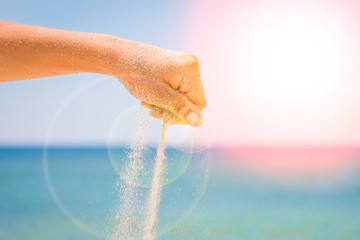 hands are pouring sand by the sea