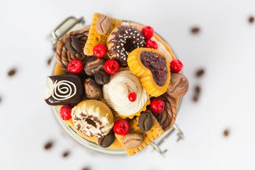 Стеклянная баночка с кофейными зернами, на который декор из полимерной глины в виде пончиков, печенья, красных ягод, конфет и зерен кофе