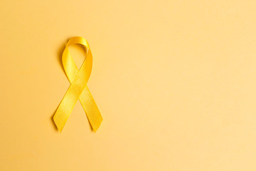 Childhood Cancer Awareness Yellow Ribbon on yellow background. Childhood Cancer Day