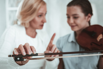 Selective focus of a violin bow in female hand