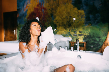 Woman relaxed in the jacuzzi covered in foam - obrazy, fototapety, plakaty