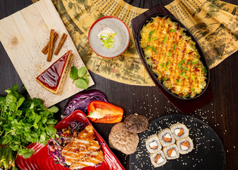 Top view flatlay japanese style business lunch including soup, salad, sushi, dessert and main meal at wooden table decorated background.