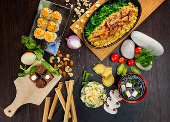 Top view flatlay japanese style business lunch including soup, salad, dessert and main meal at wooden table decorated background.