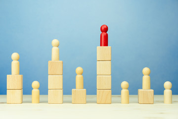 Business competition concept with wooden figure person standing on wooden blocks at different...