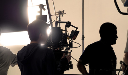Behind video camera that recording online commercial or web film movie in the big studio production...