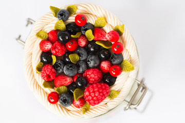 Стеклянная баночка с крышкой, на которой  декор из полимерной глины в виде свежих ягод красной и черной смородины, малины, землянике, листьев мяты и взбитых сливок