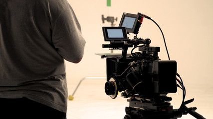 Behind video camera that recording online commercial or web film movie in the big studio production...