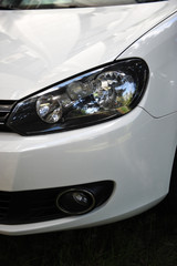 headlight of the main light of the white car, close-up.