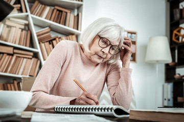 Concentrated senior female preparing task for lesson