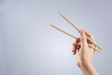 Hand holding chinese traditional sticks on gray background