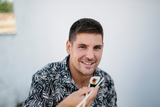 Cheerful Man Eating Sushi