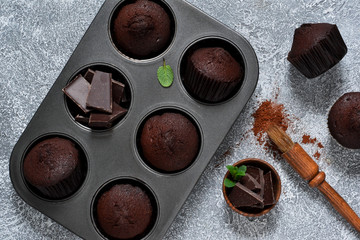 Chocolate muffins on a gray concrete background. Cupcakes. Cake.
