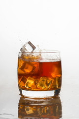 whiskey with ice in a glass with splashes