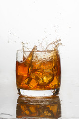whiskey with ice in a glass with splashes