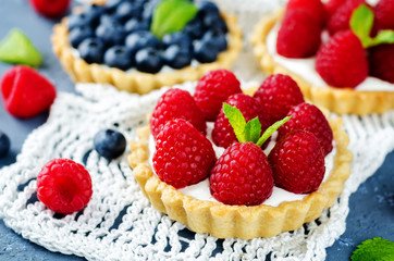 Raspberry and blueberry tartlets with fresh berries and mint leaves