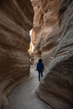 Woman hiking in the Beautiful American Canyon Landscape during a sunny evening. Taken in Kasha-Katuwe Tent Rocks National Monument, New Mexico, United States.
