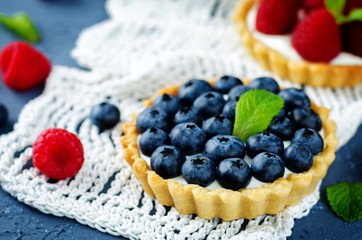 Raspberry and blueberry tartlets with fresh berries and mint leaves
