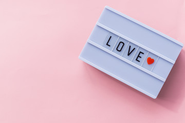 love text in a light box. Box isolated over pink background. A sign with a message.Saint Valentine's Day banner.Holiday background, festive card.Copy space.Can be used for celebrations valentines day.