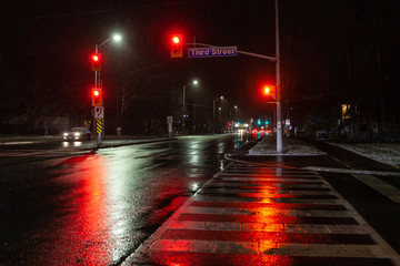 Toronto, CANADA - December 4th, 2019: Dramatic rainy night with empty streets and reflecting...