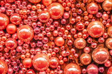 Bright abstract coral Christmas background with blurred lights and Christmas tree decoration.