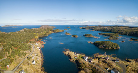 Fototapeta premium Aerial view of a small town on a rocky Atlantic Ocean Coast during a cloudy day. Taken in Pikes Arm, Newfoundland, Canada.