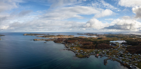 Aerial view of a small town on a rocky Atlantic Ocean Coast during a cloudy day. Taken in Twillingate, Newfoundland, Canada.