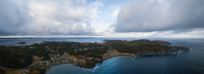Aerial view of a small town on a rocky Atlantic Ocean Coast during a cloudy day. Taken in Paradise, Twillingate, Newfoundland, Canada.