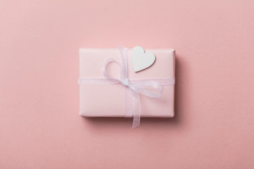 Pink valentine gift with white hearts on a pastel pink background