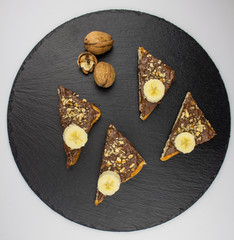Chocolate toast, nuts on a stone background. Breakfast with toast chocolate, breakfast concept. sandwich with chocolate and nuts. view from above