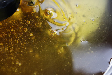Texture of sweet stretching honey. Close-up and macro of honey bubbles.