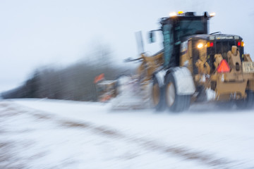 Grader Vehicle on a snow Covered Road with Motion Blur