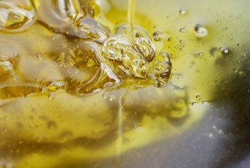 Texture of sweet stretching honey. Close-up and macro of honey bubbles.