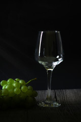 Wineglasses with grapes and corks on dark background with copy space 
