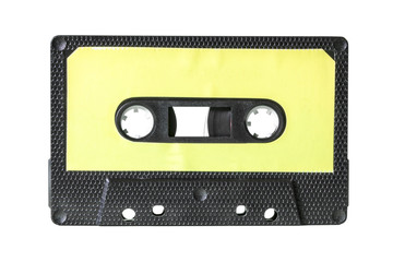 Fototapeta premium An old vintage cassette tape from the 1980s (obsolete music technology). Black hexagon grid plastic body, pale yellow empty label.