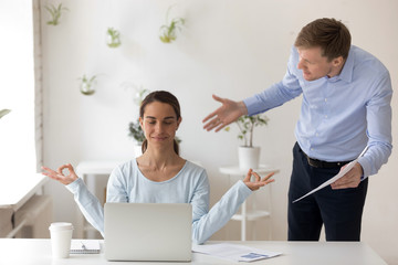Fototapeta premium Businesswoman meditating at workplace, ignoring work and annoying boss with documents, additional tasks, client, colleagues with questions, woman sitting with closed eyes, keep clam, no stress