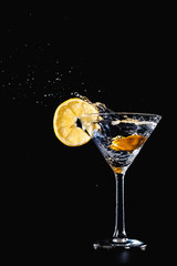 Cocktail water drink splash in the glass with lemon Isolated on black