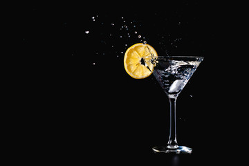 Cocktail water drink splash in the glass with lemon Isolated on black