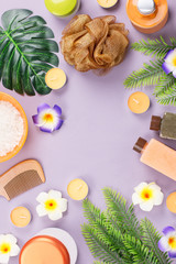 Spa and body care products flat lay. Body scrub, bath salt, moisturizing lotion, candles and leaves on wooden background