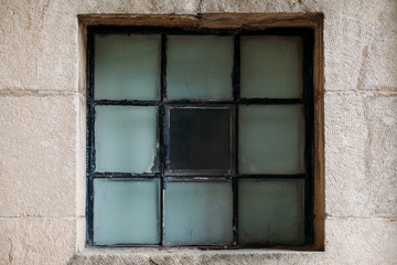 Beautiful old historic window in concrete wall of castle fortress. Texture. Background