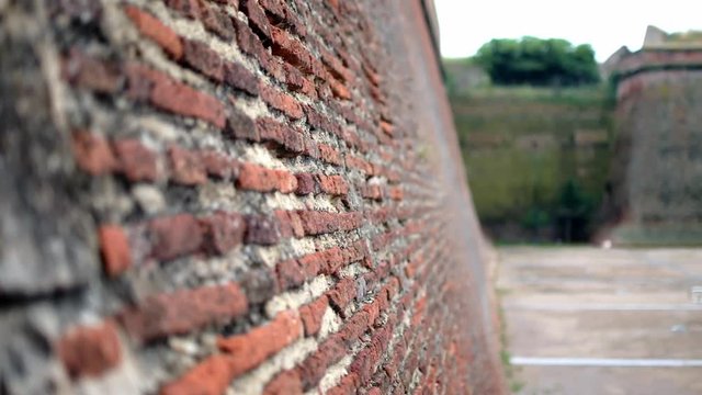 Closeup shot of the brick and morter wall of the Fort of Perpignan, France. The shot pans and opens to reveal more of the huge beautiful military building.